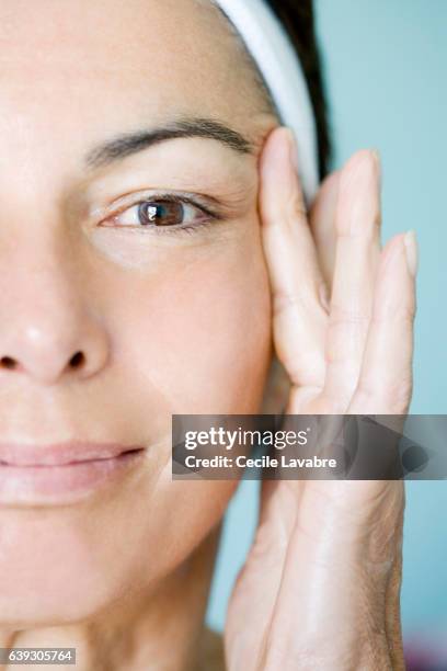 woman pulling skin of the face - pull a face foto e immagini stock