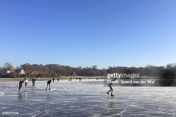 eislaufen auf einem zugefrorenen see in holland im winter - "sjoerd van der wal" stock-fotos und bilder