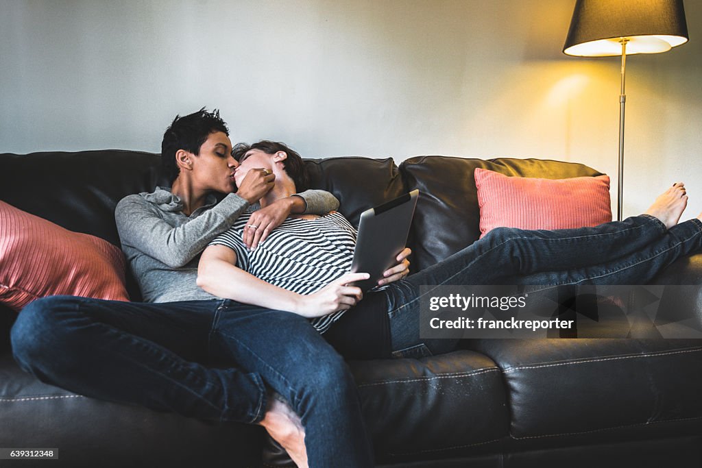 Lesbian couple share cuddling on the couch