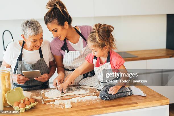 using a tablet while making cookies - grandmother baking stock pictures, royalty-free photos & images