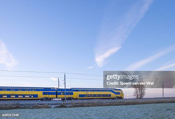 train of the dutch railways driving through frozen winter landscape - sjoerd van der wal or sjonature imagens e fotografias de stock