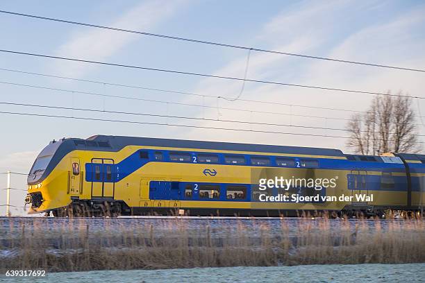 treno delle ferrovie olandesi che attraversa il paesaggio invernale ghiacciato - "sjoerd van der wal" foto e immagini stock