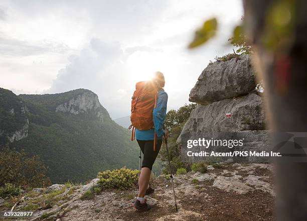 female hiker follows route marker on ridge climb - following behind stock pictures, royalty-free photos & images