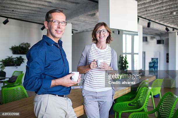 business colleagues having coffee break - man standing talking stockfoto's en -beelden