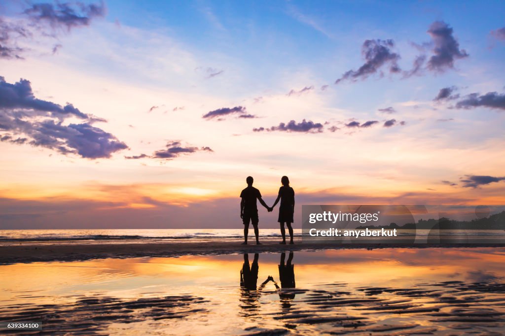 Feliz Familia En La Playa Silueta De Pareja Al Atardecer Foto de stock -  Getty Images