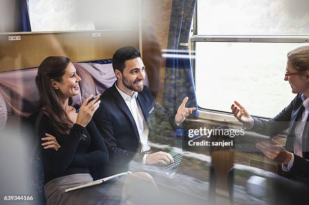 business people having a meeting on a train - ov finance review stockfoto's en -beelden