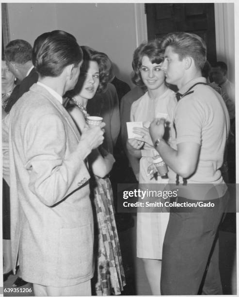 Guests mingle and enjoy refreshments at an Archives Association Party for new employees, College Park, Maryland, 1963. .