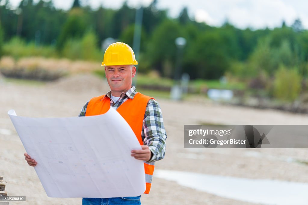 Construction worker checking blueprint