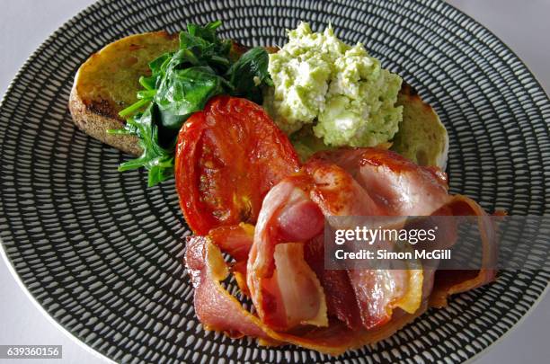 toasted sourdough bread with wilted baby spinach, avocado and fetta smash, oven roasted tomatoes and bacon - fetta - fotografias e filmes do acervo