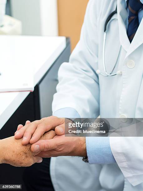 doctor holding an old woman's hand - doctor saluting stock pictures, royalty-free photos & images