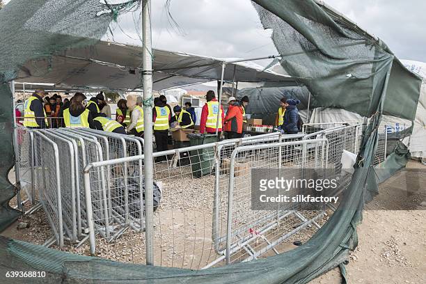 volunteers are distributing breakfast in greek refugee camp at christmas - quiosque stock pictures, royalty-free photos & images