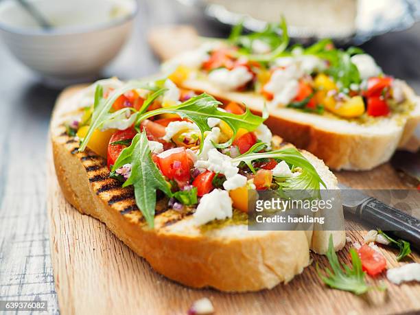 bruschetta mit tomate und rakete - häppchen stock-fotos und bilder