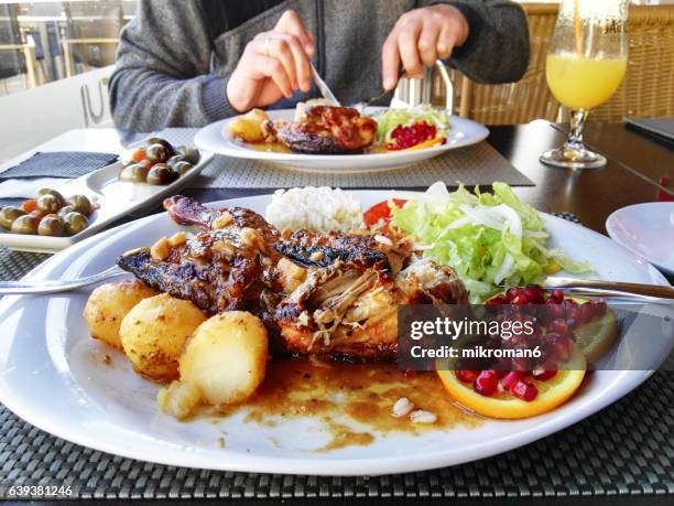 high angle view of grilled chicken with roasted potatoes, rice and orange on plate - algarve stock pictures, royalty-free photos & images