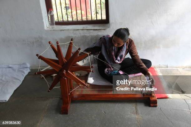 January 10. A local volunteer ably spins yarn on the spinning wheel in the verandah of the house ownedd by Gandhi. The unusually sparse home of the...