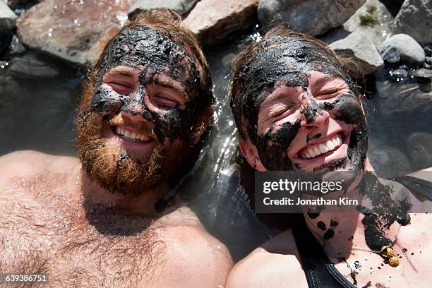 young couple in natural hot springs. - mud therapy stock pictures, royalty-free photos & images