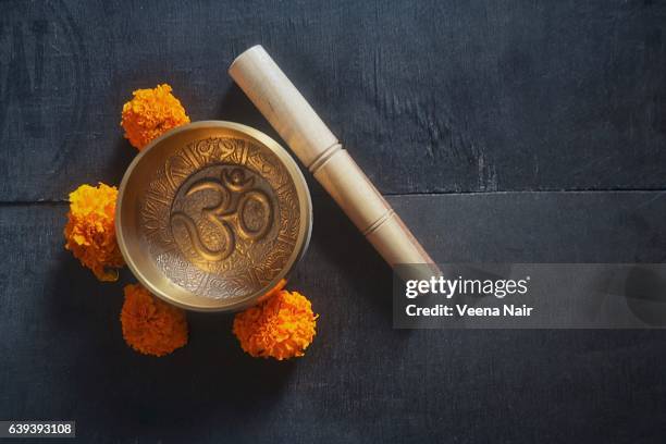 singing bowl/ rin gong with om and marigold flowers on a wooden table - rin gong 個照片及圖片檔