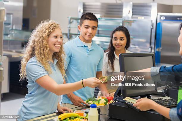 studentin zahlt kassiererin in cafeteria - buying lunch stock-fotos und bilder