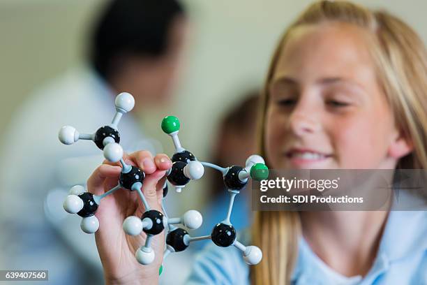 confident schoolgirl with atomic structure model - atom stock pictures, royalty-free photos & images