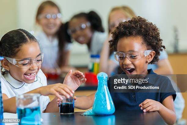 studentesse eccitate durante l'esperimento di chimica - scienza e tecnologia foto e immagini stock