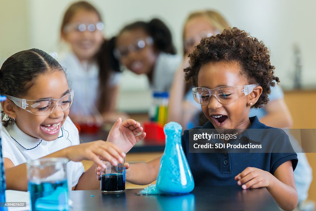 Excited school girls during chemistry experiment