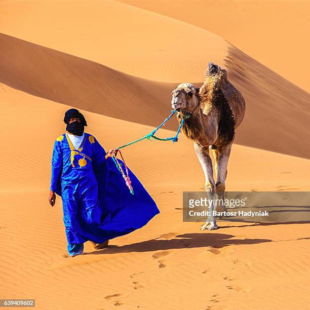 young tuareg with camel on western sahara desert in africa - toeareg stockfoto's en -beelden