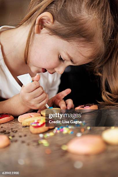 little girl making valentine’s cookie - lise gagne stock pictures, royalty-free photos & images