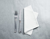 Blank white restaurant napkin mockup with knife and fork