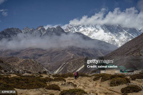 trekker on the way to everest base camp, with mountain and cloud in the background - bazar namche imagens e fotografias de stock