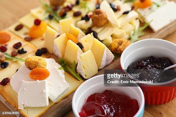 tavola da formaggio con vari tipi di formaggio e marmellata - jelly foto e immagini stock