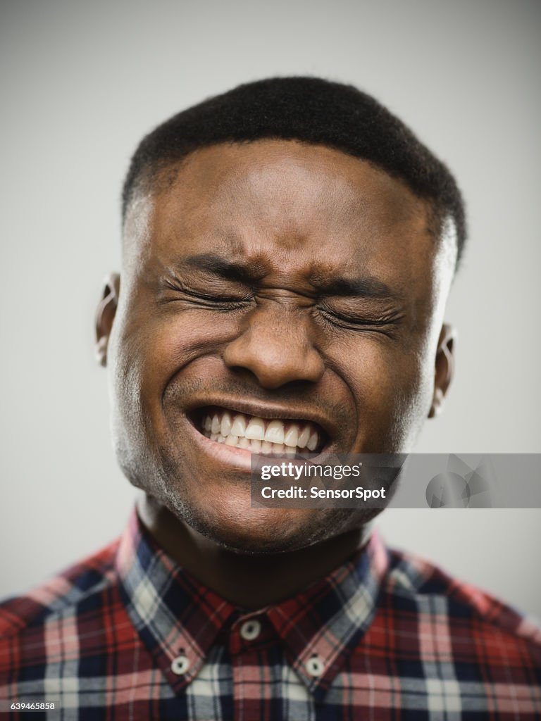 Angry man with eyes closed clenching teeth