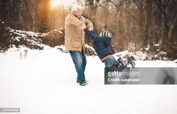 spin me faster - grandfather child snow winter stock pictures, royalty-free photos & images