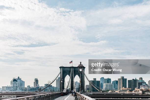 brooklyn bridge against new york cityscape - brooklyn new york stock-fotos und bilder