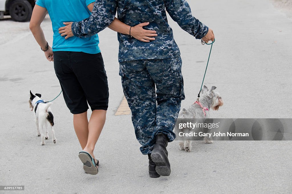 Female couple walking their dogs in street