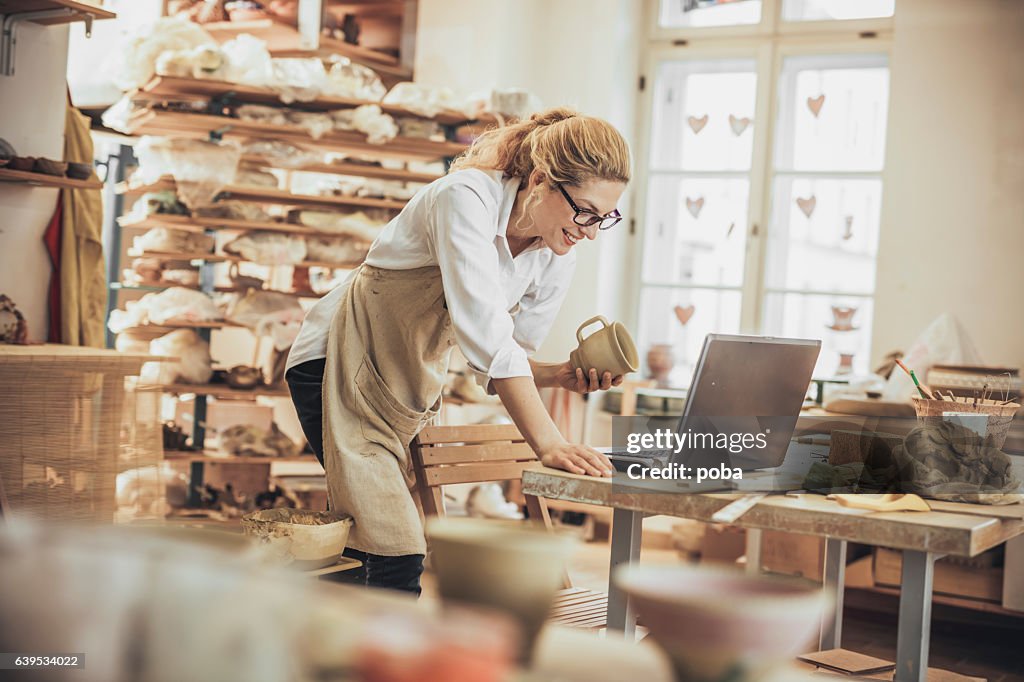 Potter-Unternehmer mit Laptop in der Werkstatt