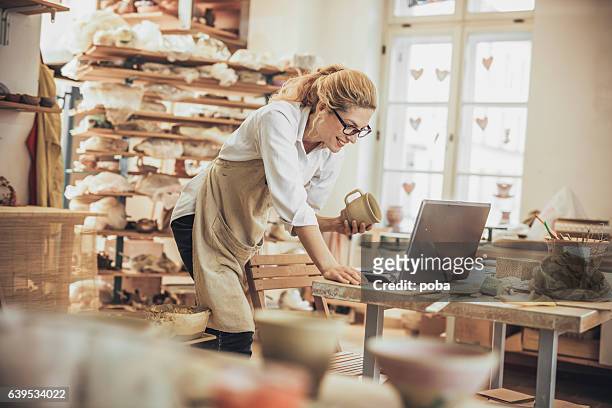 potter entrepreneur using laptop  in workshop - small business stock pictures, royalty-free photos & images