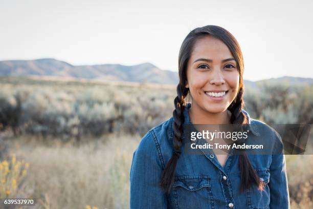 young native american woman outdoors at sunset - indianer stock-fotos und bilder