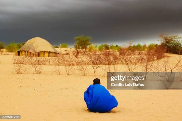 tuareg stalking at dark clouds - mali stock pictures, royalty-free photos & images