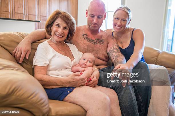 series:proud grandmother holds six week old grandson with his parents - old woman tattoos stock pictures, royalty-free photos & images
