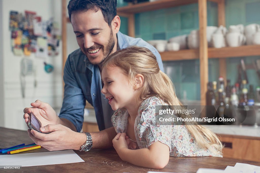 Father and daughter looking at smartphone together