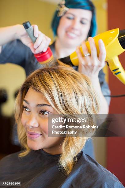 stylist drying womans hair in hair salon - blow drying hair stock pictures, royalty-free photos & images