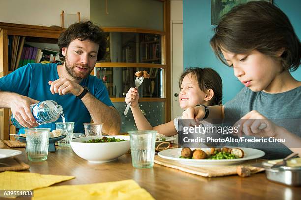 family eating dinner together - repas photos et images de collection