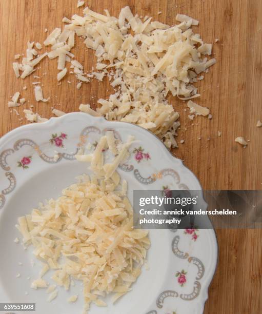 grated parmigiano-reggiano in decorated plate. - rauwe melk stockfoto's en -beelden