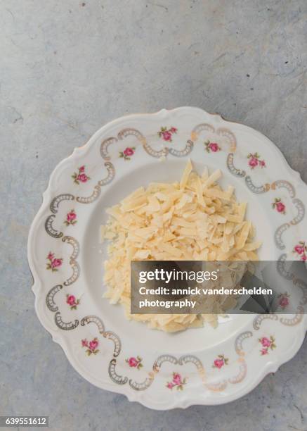 grated parmigiano-reggiano in decorated plate. - rauwe melk stockfoto's en -beelden