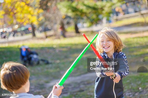 two young brothers, play fighting with laser swords - laser sword stock pictures, royalty-free photos & images