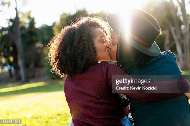 lesbian couple kissing in the park - black lesbians kiss stock pictures, royalty-free photos & images