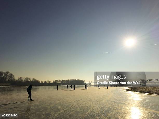 eislaufen auf einem zugefrorenen see in holland im winter - sjoerd van der wal stock-fotos und bilder