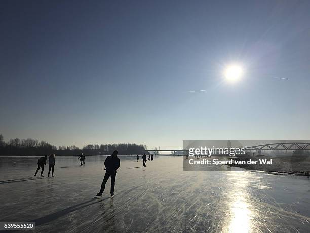 ice skating on a frozen lake in holland during winter - "sjoerd van der wal" stock pictures, royalty-free photos & images