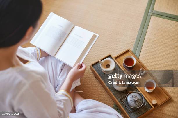 young woman reading a book and relaxing - washitsu stock pictures, royalty-free photos & images