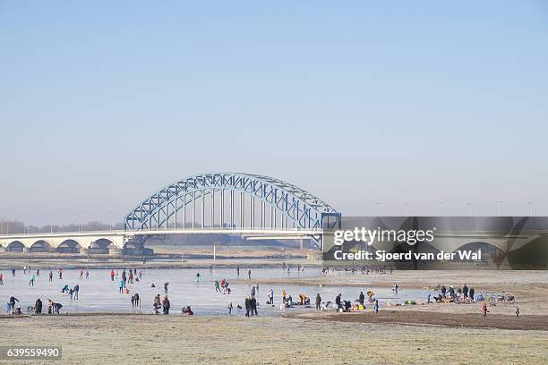 ice skating on a frozen lake in holland during winter - sjoerd van der wal stock pictures, royalty-free photos & images