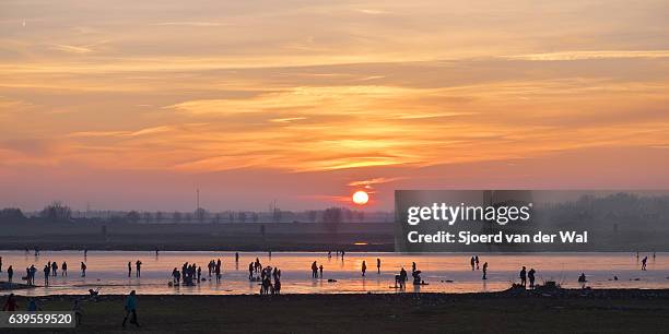 ice skating on a frozen lake in holland during winter - sjoerd van der wal or sjocar stock pictures, royalty-free photos & images